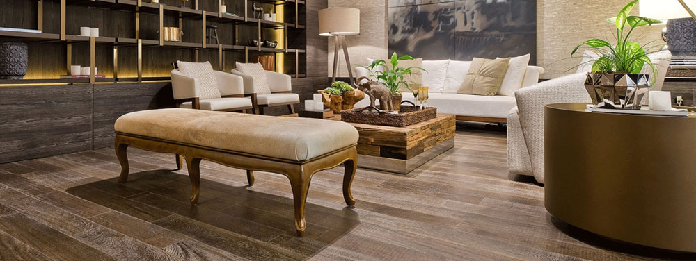 hardwood flooring in living room with white furniture, greenery and bronze accents